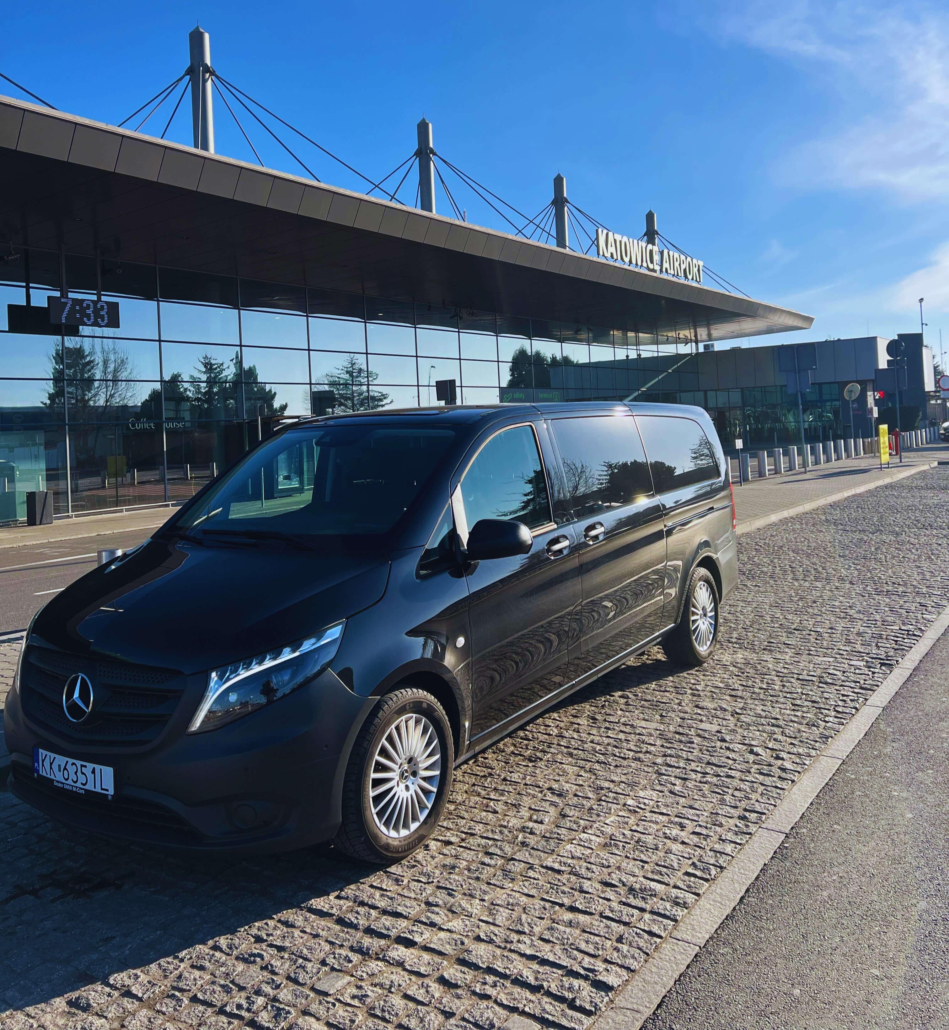 Luxury Mercedes airport transfer vehicle parked at Katowice Airport departure terminal